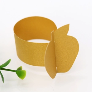 Close-up of golden pearl paper napkin ring featuring a 3D cut apple shape for party decor