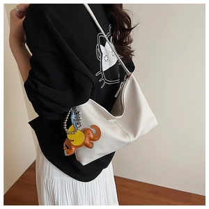 Detail of white litchi pattern leather shoulder bag with a brown elephant charm