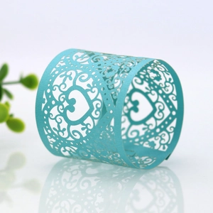 Detail of laser-cut heart napkin ring in teal paper with elegant floral patterns