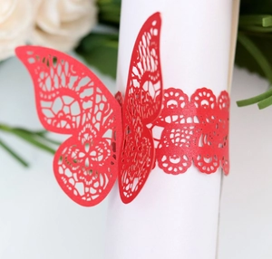Macro shot of laser-cut red butterfly paper napkin ring for elegant wedding table decor