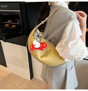 Detail of yellow dumpling bag in lychee leather with a cute elephant charm