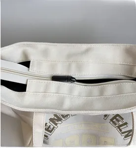 Gros plan d'une fermeture à glissière en métal lisse sur un grand sac de shopping en toile