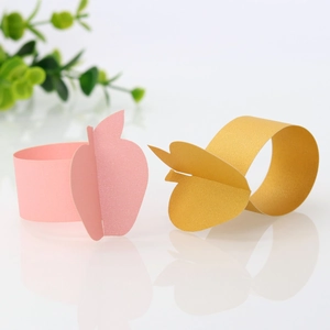 Macro view of gold and pink apple-shaped glitter cardstock napkin rings for Thanksgiving