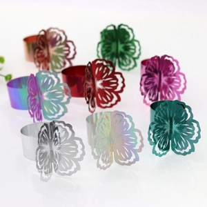 Detailed macro view of hollow flower napkin rings in various metallic finishes and colors