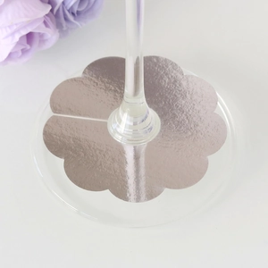 Close-up of silver scalloped wine glass base cards for party guest name identification