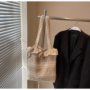 Détail du sac cabas en toile vichy avec bordures à volants et rayures tissées