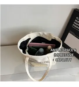 Détail du grand sac cabas en toile blanche montrant l'intérieur spacieux noir