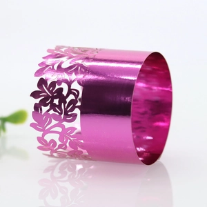 Close-up of rose red hollow flower metal napkin ring with laser cut pattern and glossy finish