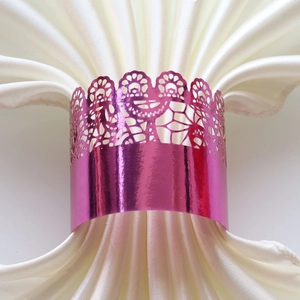 Macro detail of laser-cut purple lace napkin ring on elegant white satin napkin
