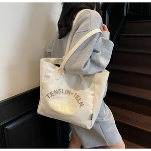 Grand sac cabas en toile avec imprimé vintage porté à l'épaule par un mannequin