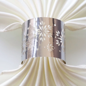 Macro detail of silver snowflake metal napkin ring with white silk cloth decoration