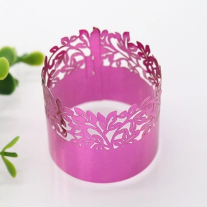 Detail of rose red hollow flower napkin ring with elegant laser-cut leaf patterns