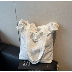 Détail du sac fourre-tout blanc avec bords à volants et tissu seersucker gaufré