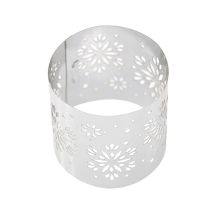 Macro shot of silver metal napkin ring featuring hollowed-out snowflake patterns for Christmas