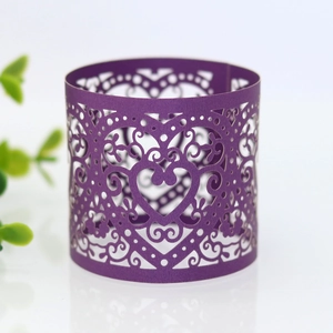 Detail of dark purple laser cut napkin ring with heart pattern and scrolling vines
