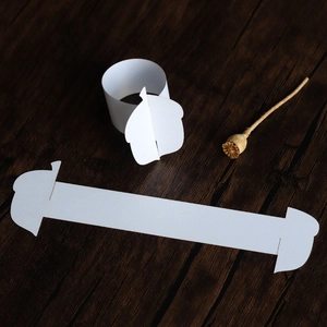 Detailed close-up of white paper napkin rings with acorn-shaped interlocking design