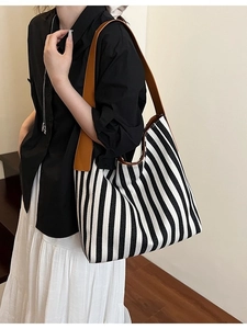 Minimalist black and white striped canvas tote bag with brown leather shoulder straps
