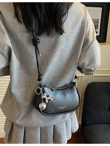 Retro black crossbody dumpling bag with shiny pleated texture and silver balloon dog charm