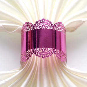 Detailed macro view of laser-cut purple metallic napkin ring with intricate floral lace pattern