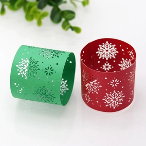 Close-up of delicate hollow snowflake napkin rings in festive red and green paper