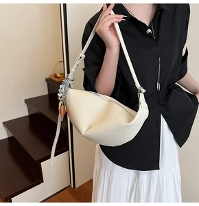 Chic beige half-moon hobo bag with adjustable strap and decorative scarf detail