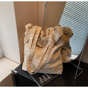Gros plan détaillé du sac cabas en toile à carreaux jaunes et blancs avec broderies