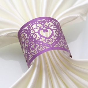 Close-up of purple laser-cut heart paper napkin ring with elegant hollow scroll patterns