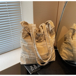 Détail du sac cabas à carreaux jaunes et blancs avec rayures horizontales brodées