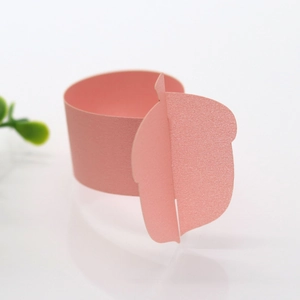 Detail of laser-cut pink pearlescent paper napkin ring with leaf shape and shimmer texture