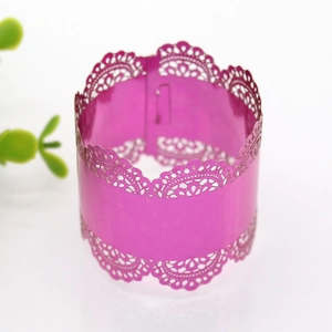 Detail of laser-cut magenta napkin ring with elegant lace pattern for wedding decor