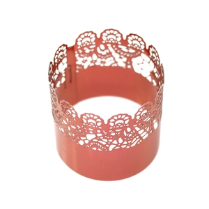Macro view of coral pink laser cut lace cupcake wrappers with intricate floral patterns