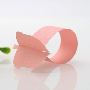 Detailed view of 3D pink paper napkin ring with a delicate butterfly cutout design