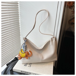 Detail of off-white lychee texture tote bag with a cute leather elephant charm