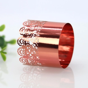 Close-up of rose gold lace napkin ring with laser-cut hollow pattern for wedding decor
