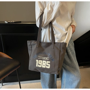 Détail du sac cabas en toile gris foncé avec imprimé vintage 1985 et doubles anses robustes
