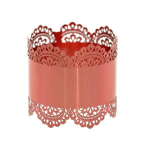 Detail view of laser-cut rose gold napkin ring with intricate lace patterns and shiny finish