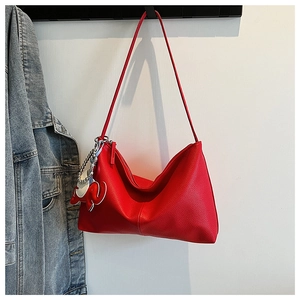 Detail of red pebbled leather hobo bag with zip closure and cute elephant charm