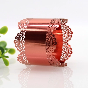 Close-up of shiny metallic red napkin ring with intricate lace hollowed patterns