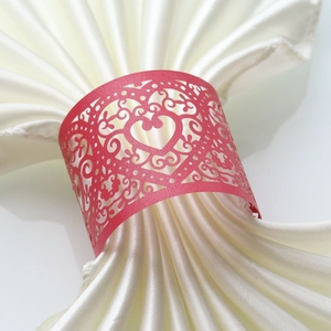 Macro view of laser-cut pink heart napkin ring with floral hollow patterns