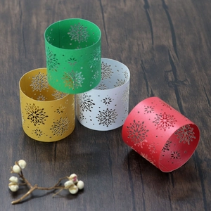 Detailed view of hollow snowflake paper napkin rings in red, green, gold, and white colors