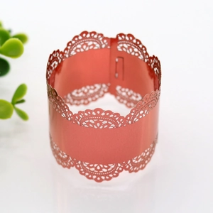Close-up of laser-cut lace napkin ring in coral red with a pearlescent finish