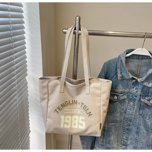 Détail du sac fourre-tout en toile de coton beige avec imprimé 1985 et poche