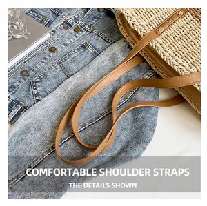 Close-up of woven straw shoulder bag with brown leather straps on denim jacket
