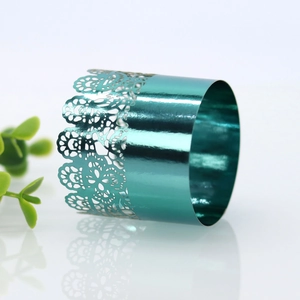 Macro shot of teal laser-cut lace napkin ring with a polished metallic mirror finish