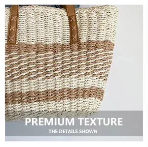 Detail of woven straw tote bag featuring reinforced brown faux leather handle stitching