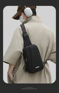 Detailed close-up of a black nylon crossbody bag with MACHUGE logo on a male model
