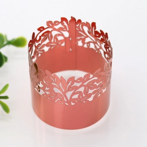 Detail of rose gold napkin ring featuring intricate laser-cut hollow leaf textures