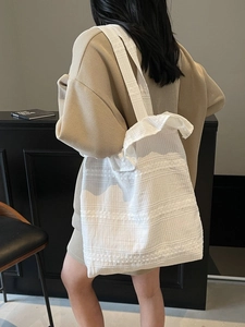 Sac fourre-tout minimaliste en toile blanche avec motif jacquard rayé porté à l'épaule