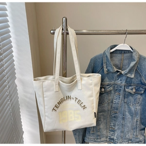 Détail de l'imprimé vintage sur un sac fourre-tout en toile blanche suspendu