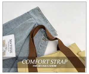 Close-up of yellow canvas tote bag showing reinforced brown cotton shoulder strap detail